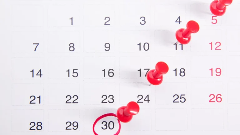 A calendar with red pins marking dates