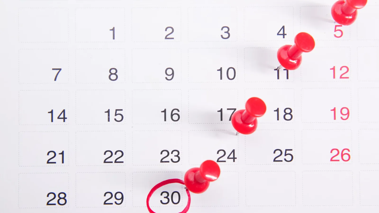 A calendar with red pins marking dates